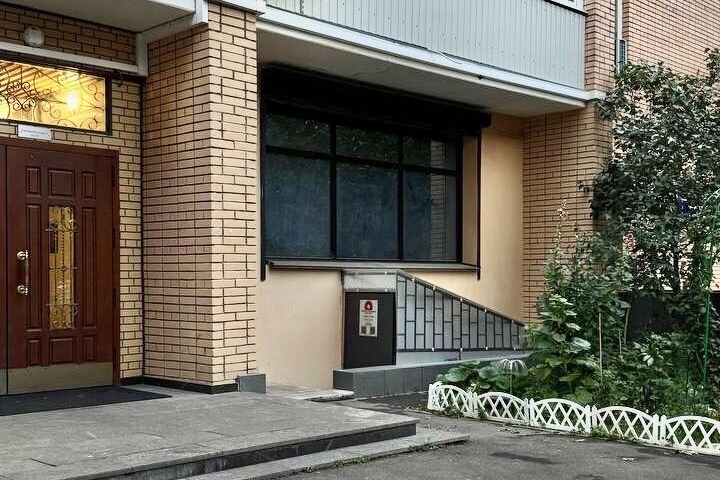 Двор на Украинском бульваре: тёмная дверь школы под металлической лестницей, рядом деревянная дверь подъезда